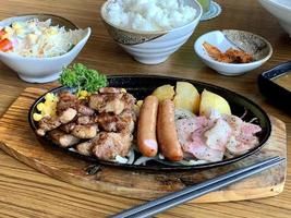 Various menus, sushi, sashimi, nigiri, pan fried pork and miso soup. Sashimi, chutoro sashimi, Japanese food chopsticks and wasabi on the black table, Japanese food style. blurs focus. photo