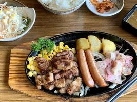 Various menus, sushi, sashimi, nigiri, pan fried pork and miso soup. Sashimi, chutoro sashimi, Japanese food chopsticks and wasabi on the black table, Japanese food style. blurs focus. photo