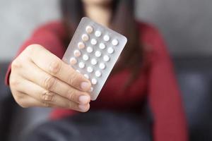 Women holding birth control pills photo