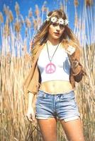 hippie girl with flowers crown if peace symbol photo