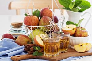 Apple juice and fresh apples on the table photo