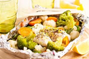 pollo al limón con verduras cocidas en papel de aluminio foto