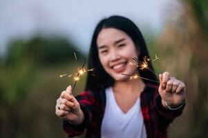 Asian pretty girl holding burning sparkler celebration in New year photo
