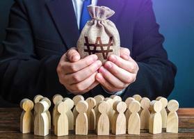 Businessman holds out a south korean won money bag to the crowd. Official. Staff maintenance. Tax collection. Compensation payments. Providing money, paying salaries and grants. Financial support. photo