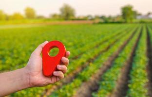 pasador de ubicación rojo en el campo de la granja. compra y venta de terrenos. mercado de tierras servicio de deslinde de parcelas. regulación jurídica de la propiedad. agricultura y agroindustria. inversión del propietario. sitio de alquiler foto