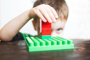 child boy playing with plastic constructor photo