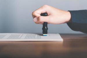 Businessman validates and manages business documents and agreements, signing a business contract approval of contract documents confirmation or warranty certificate,approval stamp photo