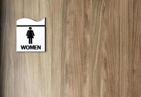 Wooden toilet door with sign on it text Woman. Copy space photo