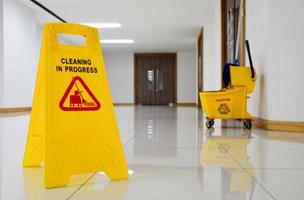 Close up yellow warning sign with message Cleaning in progress photo