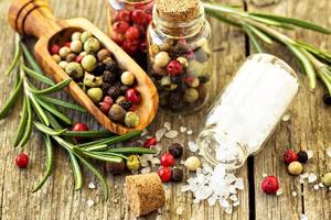 Spices, herbs and different kinds of pepper on wooden table photo