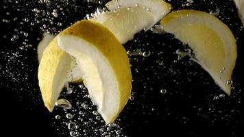 Sliced lemons fruit splashing in water video