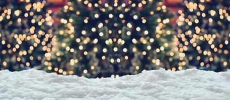 Empty white snow with blur Christmas tree with bokeh light background photo