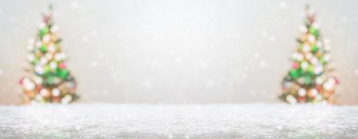 Empty white snow with blur Christmas tree with bokeh light background photo