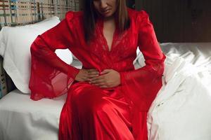 Symptoms of Appendicitis, Illustration of the uterus is on the woman's body. Enteritis, People in satin red nightgown having belly ache photo