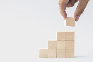 hand arranged stacked wooden cubes as steps on white background. concept about education, business, play, strategy, and success. photo