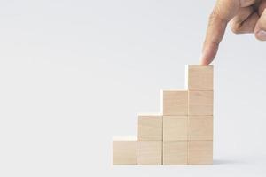 hand arranged stacked wooden cubes as steps on white background. concept about education, business, play, strategy, and success. photo