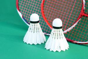 volantes blancos sobre fondo verde, fondo de raqueta de bádminton borroso. enfoque suave y selectivo. foto