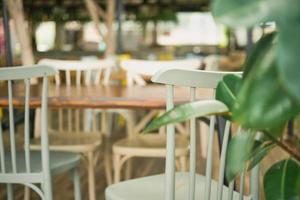 Close-up of wooden chairs in a street cafe. Selective focus on a chair close up. Bar view, focus blur, bar decoration idea or photo for interior