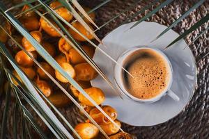 Cup of strong espresso coffee and fresh dates top view. Idea for breakfast. Date harvest on the farm idea for background or product advertising photo