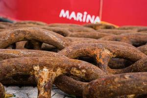 Close-up on the links of an old rusty ship's chain in the marina, selective focus. Idea for the background, the concept of shipping and recycling of materials photo