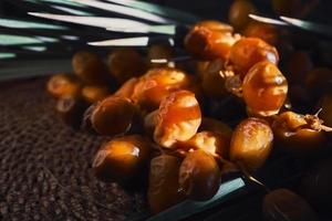 Close-up fresh dates in the sun are drying on a mat, dark background, selective focus. Date harvest on the farm idea for background or advertising photo