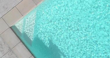Étape abstraite aérienne et eau de piscine avec ombre de personne passant l'aspirateur video