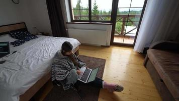 Woman uses laptop on bedroom floor video