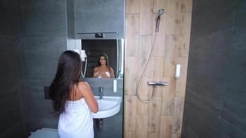 Woman with long hair shakes water off after shower video