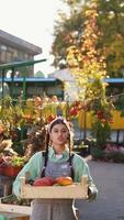 Woman holds pumpkin and talks at fall market display video