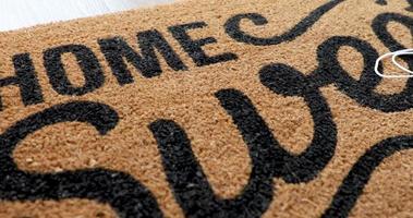 Pan Over Home Sweet Home Welcome Mat With Medical Face Masks Resting on Floor video