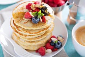 pila de tortitas de avena esponjosas con bayas frescas foto