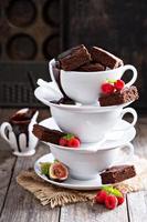 brownies en tazas de café apiladas con salsa de chocolate
