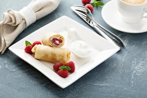 Crepes filled with cottage cheese and raspberry photo