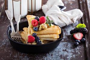 Thin pancakes with apples and fresh berry photo