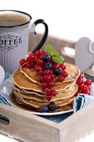Pancakes with mixed berries isolated on white