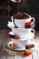 brownies en tazas de café apiladas con salsa de chocolate
