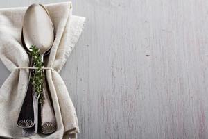 cucharas vintage y tomillo en una servilleta foto