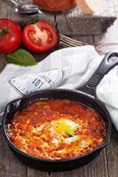 Shakshuka with tomatoes and eggs photo