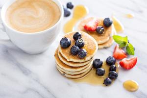 Stack of small pancakes with fresh berries photo