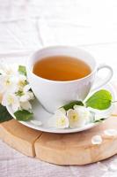 Jasmine tea in a cup with fresh flowers photo