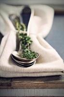 Vintage spoons and thyme on a napkin