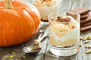 tarta de queso de calabaza en capas en un vaso, postre de otoño foto