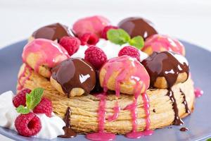 Saint-Honore cake with chocolate and raspberry photo