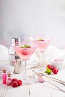 Raspberry martini on white table photo