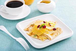 Thin crepes with citrus sauce and dried cranberry photo