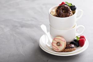 pequeños mini donuts en tazas de café apiladas foto