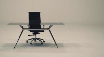 Table with top glass and leather armchair. photo