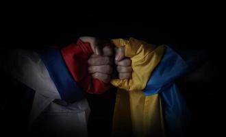 Russian flag and Ukraine flag in hands showing symbol of struggle war photo