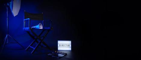 silla de director con texto de director de cartel de caja de luz de cine y megáfono de claqueta foto