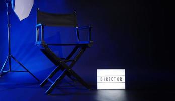 silla de director con texto de director de cartel de caja de luz de cine y megáfono de claqueta foto
